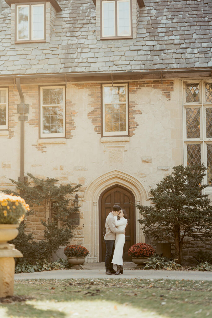 couple kissing in front of plummer house building in Rochester, MN