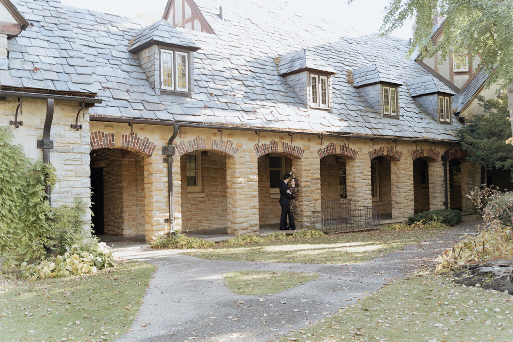 couple in front of an archway brick building 