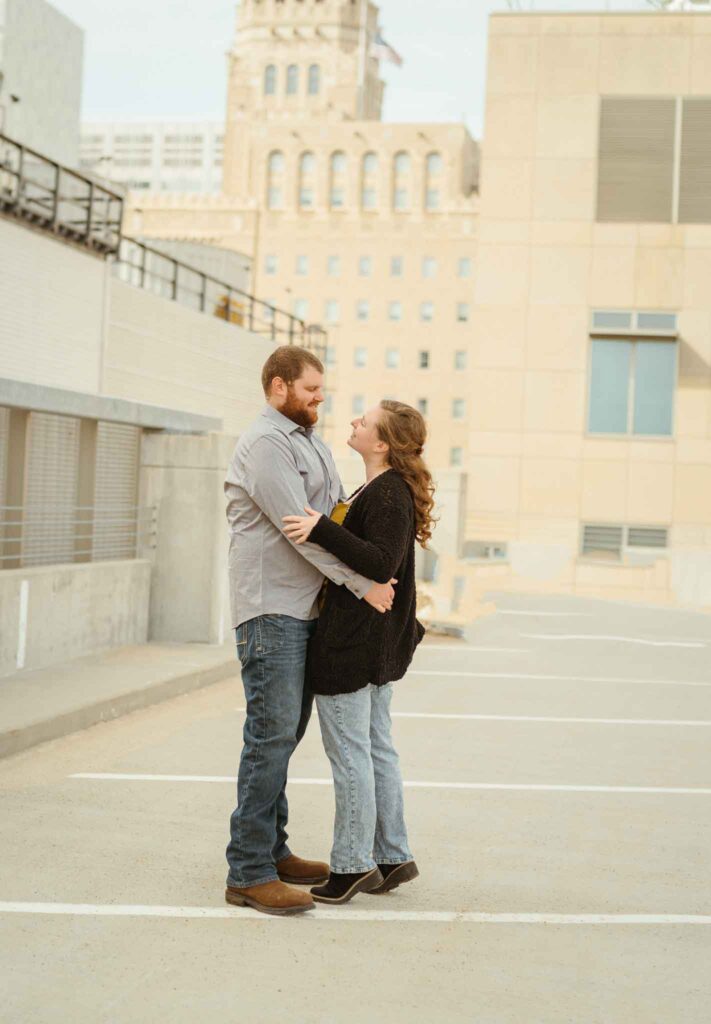 couple looking at each other at a downtown rooftop in Rochester mn