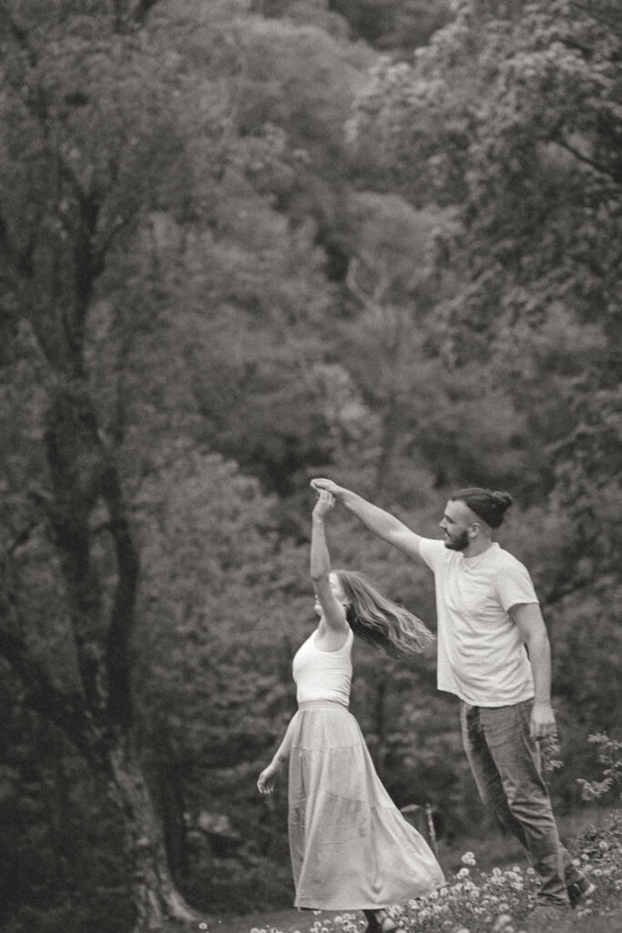 black and white engagement photos of nature of couple dancing
